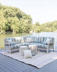 Classic Terrace Sectional with striped cushions in Gateway Mist color, set on a dock overlooking a serene lake and surrounded by greenery, perfect for outdoor relaxation.